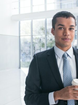 a man in a suit holding a cup of coffee