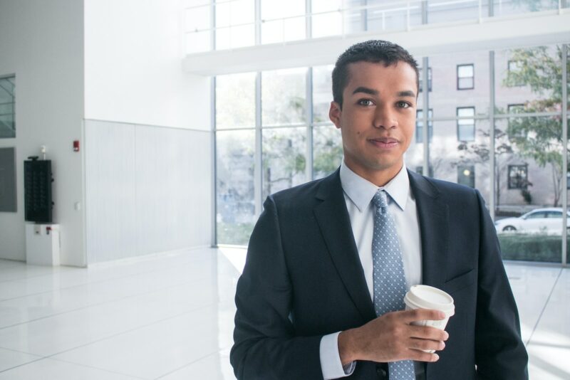 a man in a suit holding a cup of coffee